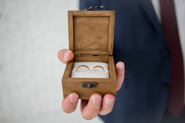 wooden box for wedding rings in the hands of the groom
