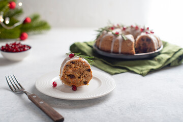 Christmas fruit cake, pudding with rosemary sprigs and red berries on a gray background. Copy space. Traditional New Year's dessert.