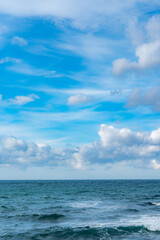 Naklejka na ściany i meble 青空に浮かぶ雲とエメラルドグリーンの海の地平線