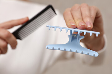 Female hairdresser holding clasp ans Comb, Preparing To Give A Haircut close up