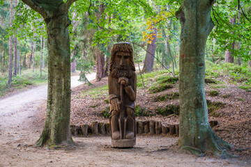 Old man of the forest wooden statue between two trees