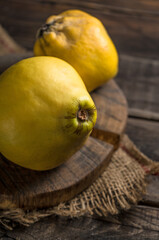 Fresh yellow quinces on rural wooden background