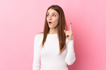 Young woman over isolated pink background thinking an idea pointing the finger up