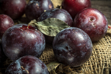 Autumn plums on wooden background, rural still life