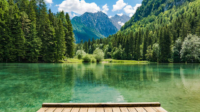Amazing view of green lake surrounded by trees and mountains. Zgornje Jezersko, Slovenia,