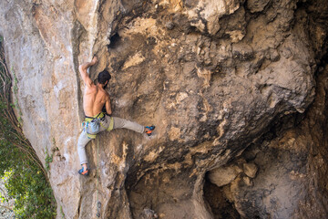 A man trains strength and endurance, rock climbing in Turkey