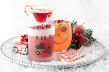 Fresh Christmas cocktails on a metal serving tray against a bright background.