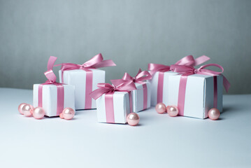 White gifts with pink ribbons. Set of gift box isolated on white background.Christmas gift boxes on white background. Beautiful Christmas background with shiny balls and ribbons in pastel pink color. 