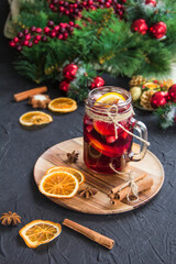 Christmas hot mulled wine with cinnamon cardamom and anise. Dark vintage dirty background. Creative atmospheric decoration