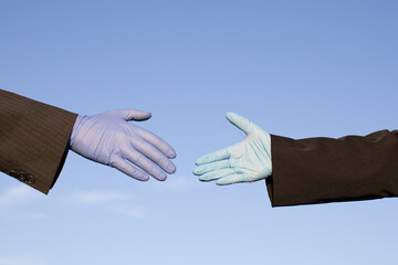 people wearing protective gloves reaching out for handshake