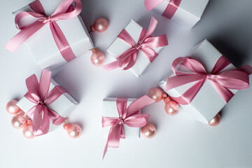 White gifts with pink ribbons. Set of gift box isolated on white background.Christmas gift boxes on white background. Beautiful Christmas background with shiny balls and ribbons in pastel pink color. 