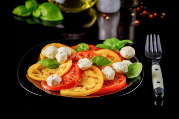 Sliced tomato with mozzarella, basil and spices.