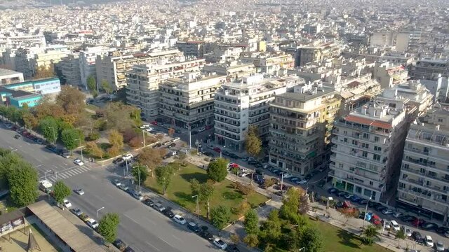 Aerial view of urban environment in the city of Thessaloniki, Greece, main road with cars and trees, east side, circular movement by drone
