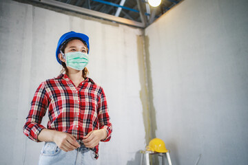 Engineer or Foreman woman wearing disposable face mask before working to protecting viruses (COVID-19) and dust on construction sites