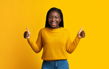 I Like It. Joyful African Woman In Bright Sweater Showing Thumbs Up