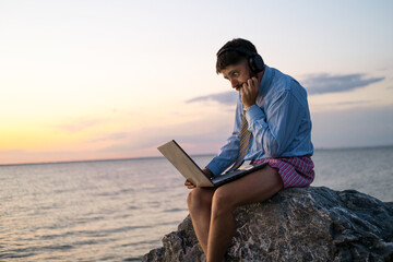 manager works remotely on the seashore at sunset. He is wearing a shirt with a tie, underpants. He experiences the emotion of surprise. Stay home and quarantined.