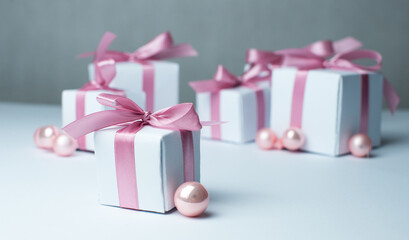 White gifts with pink ribbons. Set of gift box isolated on white background.Christmas gift boxes on white background. Beautiful Christmas background with shiny balls and ribbons in pastel pink color. 