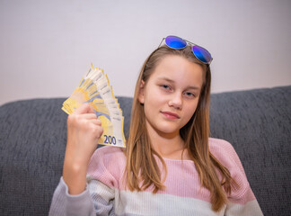Girl is wagging with a fan of 200 Euro notes