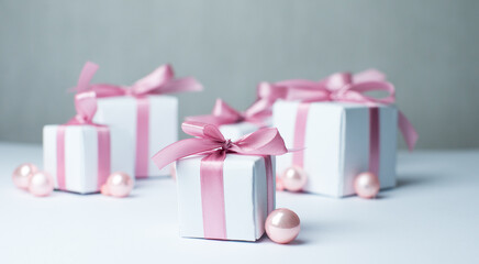 White gifts with pink ribbons. Set of gift box isolated on white background.Christmas gift boxes on white background. Beautiful Christmas background with shiny balls and ribbons in pastel pink color. 