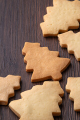 Close up of plain gingerbread Christmas tree cookie on wooden background.