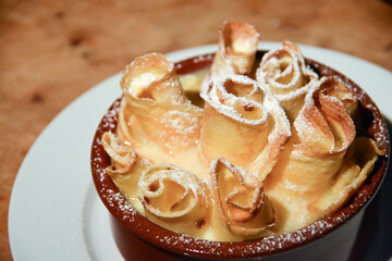 closeup of gratinated pancakes with sugar topping in vanillia sause