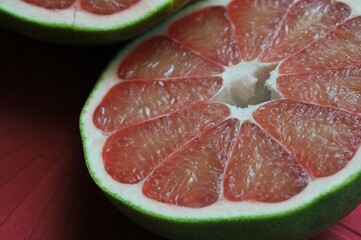 A close up of the surface of the red pomelo petals on the red colour  background , Red pomelo , cut into half , Texture of pomelo meat