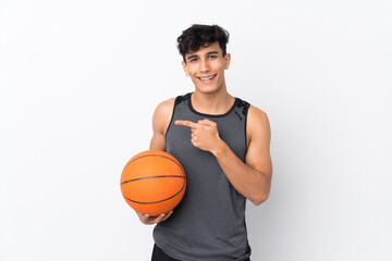 Basketball player man over isolated white background surprised and pointing side