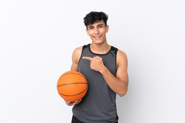 Obraz premium Basketball player man over isolated white background surprised and pointing side