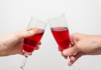 Crop close up of man and woman hold glasses with rose champagne or vine clink greet congratulate with valentines day against white background.Hands holding the glasses of champagne and wine making a