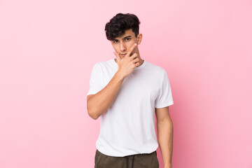 Young Argentinian man over isolated pink background thinking an idea