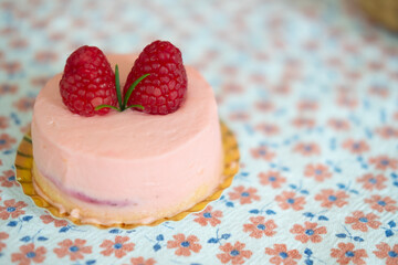 Cream rose mousse dessert on top with raspberry