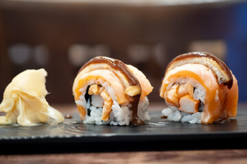 Maki sushi smoked salmon on top with cheese and sauce.