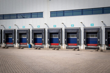 Row of loading docks with shutter doors at an industrial warehouse.