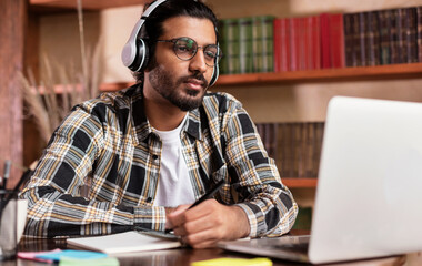 Arab Student Guy Learning Online At Laptop Sitting In Library