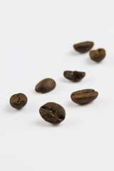 a few isolated coffee beans on a white background, a close-up