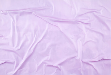 Crumpled purple paper poster glued on rough surface. Abstract creative background of glossy wavy magazine paper.