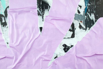 Torn and peeling purple poster glued on billboard with old dirty paper. Abstract and creative background of ripped purple glossy magazine paper.