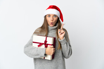 Lithianian woman with christmas hat holding presents isolated on white background intending to realizes the solution while lifting a finger up