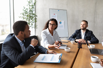 Coworkers At Corporate Meeting Discussing Work Sitting In Modern Office