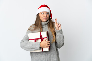 Lithianian woman with christmas hat holding presents isolated on white background with fingers crossing and wishing the best