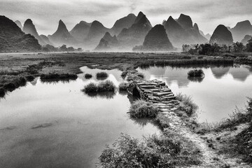 Fototapeta premium ancient stone bridge crossing with the mountains of Guilin in the background - beautiful landscape in China