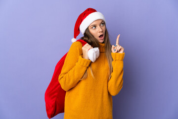 Lithianian woman with christmas hat isolated on purple background thinking an idea pointing the finger up