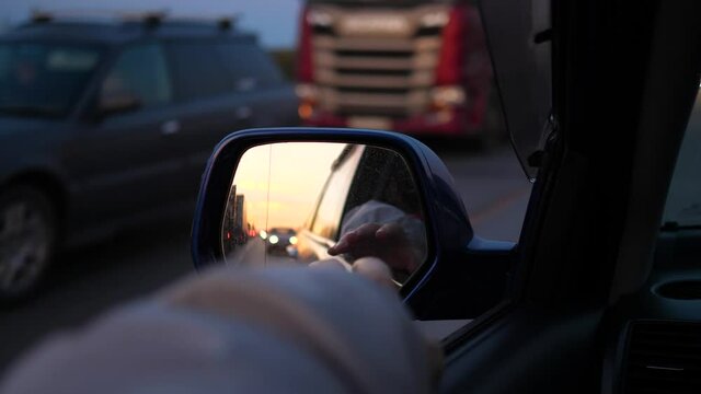 Family trip. The family is driving on the highway. Reflection in the mirror. Sunset time