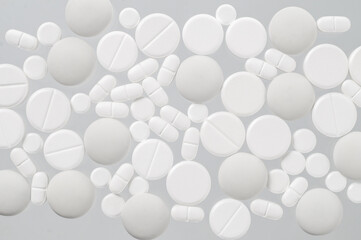 Various white medical pills on white background