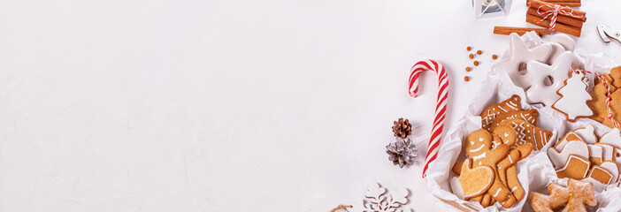Top view of unpacked christmas present with sweets on a white textured surface, banner, close-up....