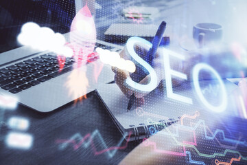 Multi exposure of woman's hands making notes with SEO icon. Concept of Search engine optimization