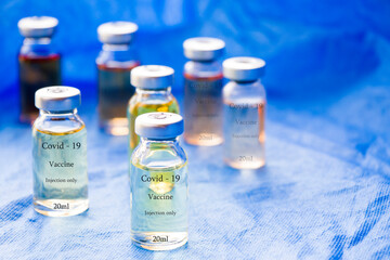 Corona virus and Covid - 19 new vaccine in ampules, different color variations of vaccine