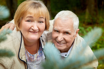 Elderly couple walking in the park on an autumn day.