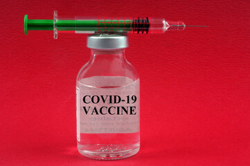 Concept de vaccin contre le covid-19 avec un flacon et une seringue sur fond rouge