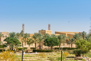 Green date trees growing in the park in the Ruins of Diraiyah, also as Dereyeh and Dariyya, a old town in Riyadh, Saudi Arabia